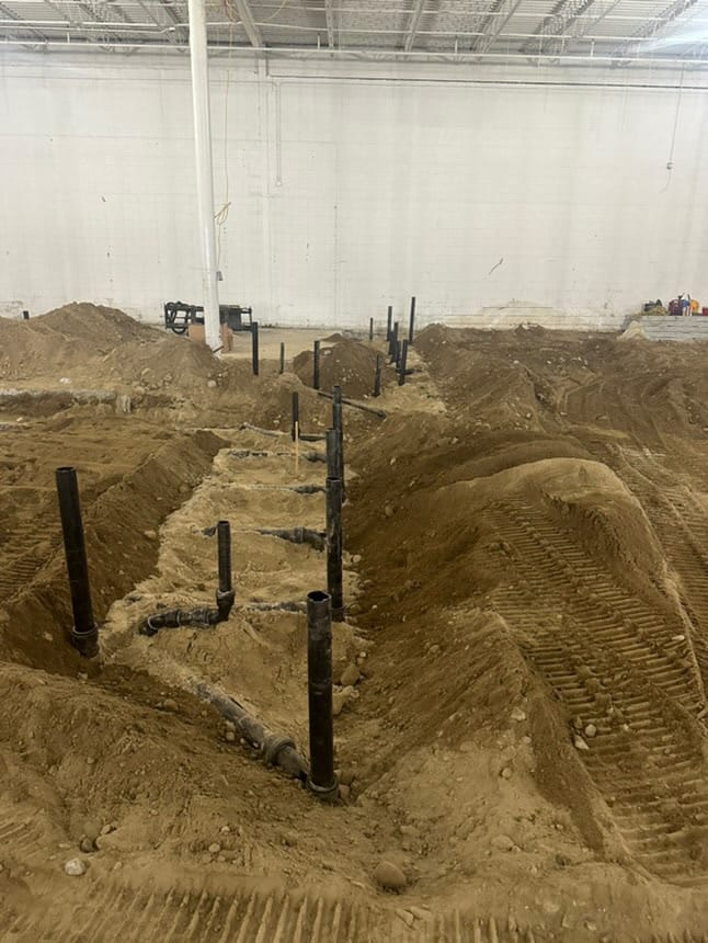 Commercial plumbing installation with underground drainage pipes in a construction site.