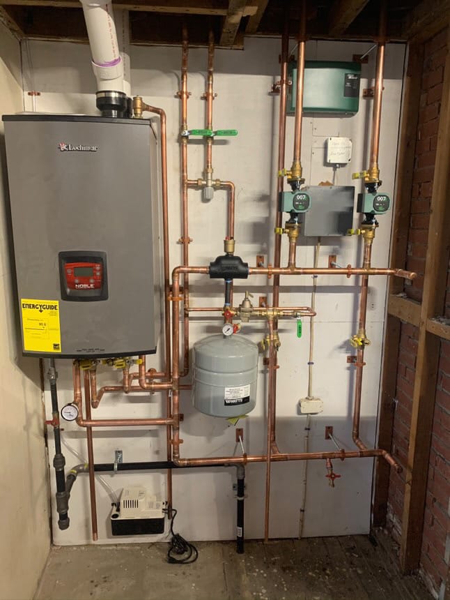 High-efficiency Lochinvar boiler system with copper piping, expansion tank, and circulation pumps installed in a basement.